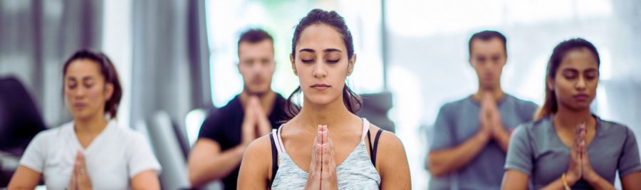 Una donna medita durante una lezione di yoga, circondata da altri partecipanti in un ambiente tranquillo. Una donna medita durante una lezione di yoga, circondata da altri partecipanti in un ambiente tranquillo.