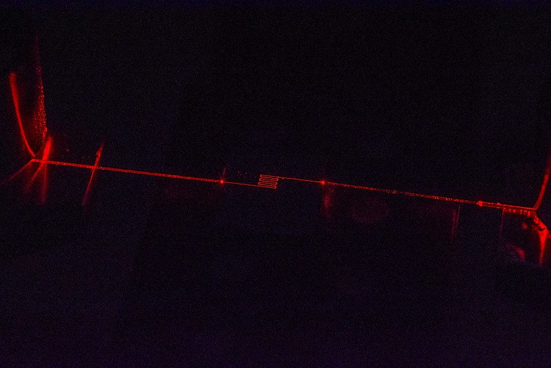 Integrated optics chip with photonic devices specifically developed for the visible light range, horizontally coupled with two optical fibers for RGB and sensor applications.