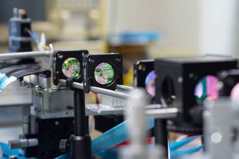 Setup for infrared light free space propagation, with mirrors, lenses and beam splitters. On the back plane it is also possible to see the PCB, connected to the control circuit, where the integrated optics chip is housed. In this case the role of photonics is the manipulation of the beam, both on trasmission and reception.