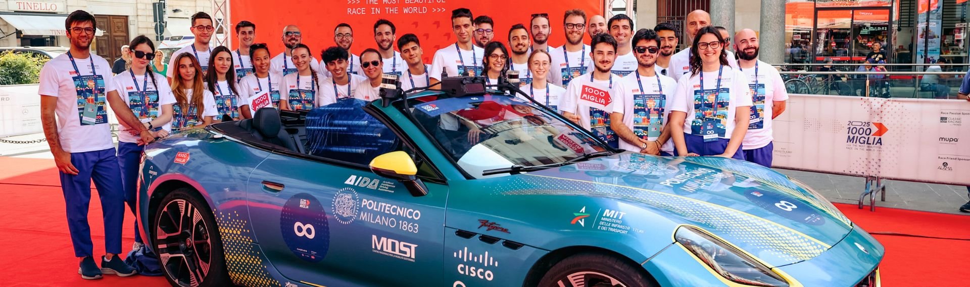A group of people standing up next to a car. A group of people standing up next to a car.