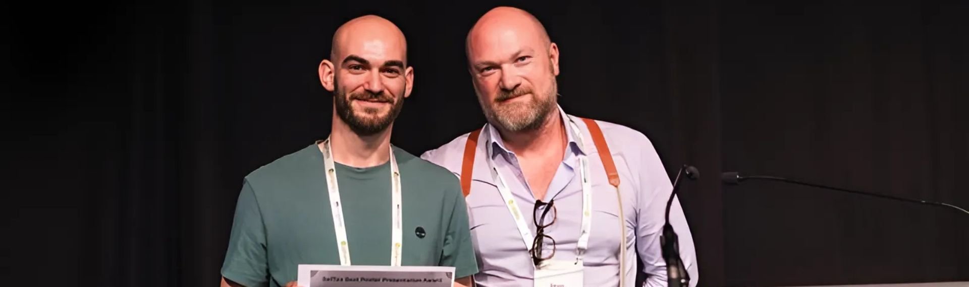 Due uomini in piedi uno accanto all'altro, tengono un certificato tra le mani. Due uomini in piedi uno accanto all'altro, tengono un certificato tra le mani.