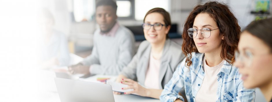 Un gruppo di persone sedute a un tavolo, ognuna con un laptop aperto, impegnate in un'attivit collaborativa.